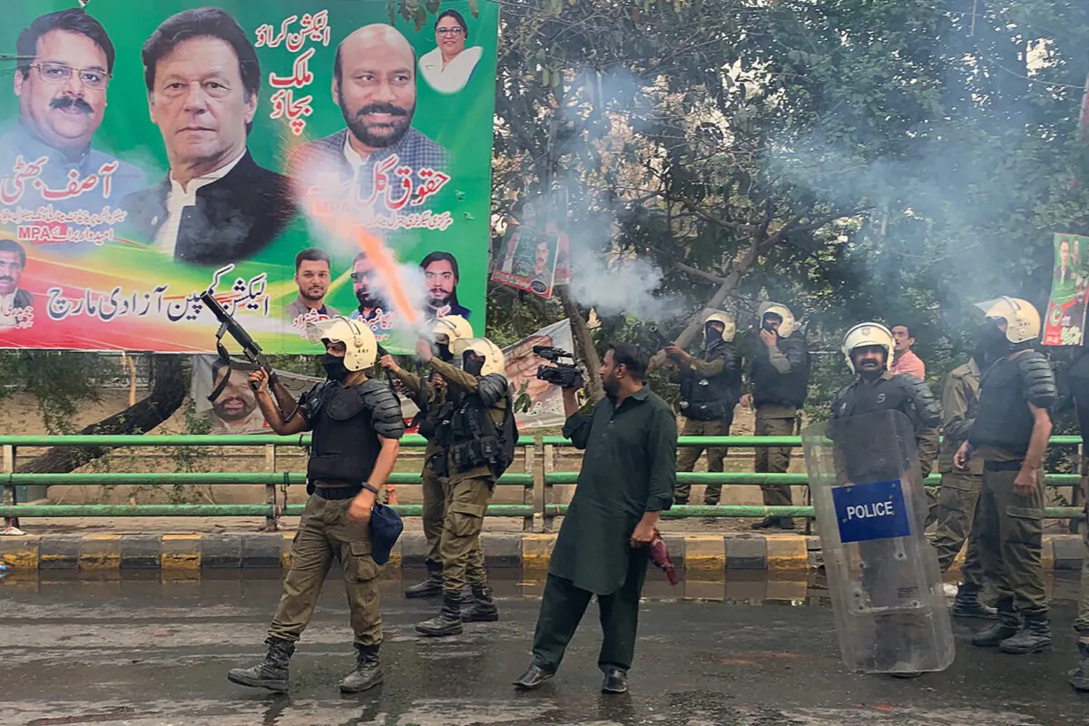 Riot police fire teargas shells to push back supporters of former prime minister Imran Khan gathered outside Khan's house to prevent officers from arresting him, in Lahore on March 14, 2023. (Arif Ali/AFP via Getty Images)