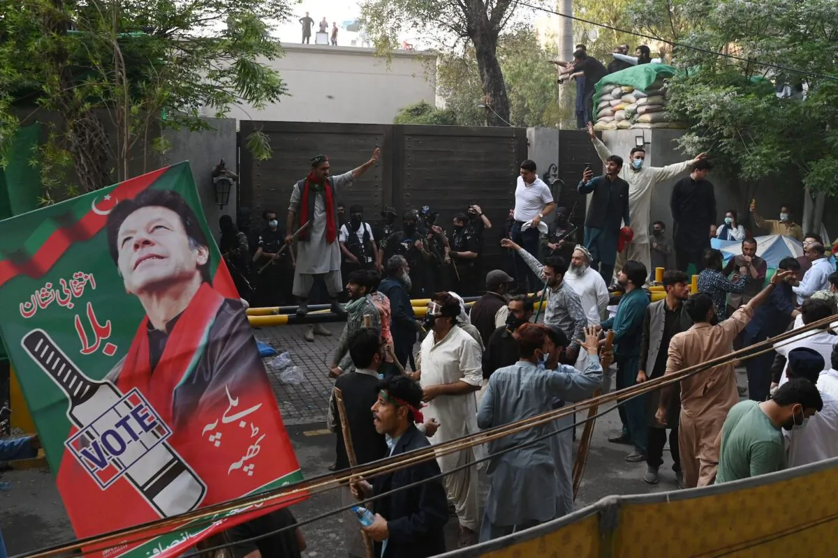 Supporters of former Prime Minister Imran Khan gather outside Khan's house to prevent riot police officers from arresting him, in Lahore, Pakistan, on March 14, 2023. (Arif Ali/AFP via Getty Images)