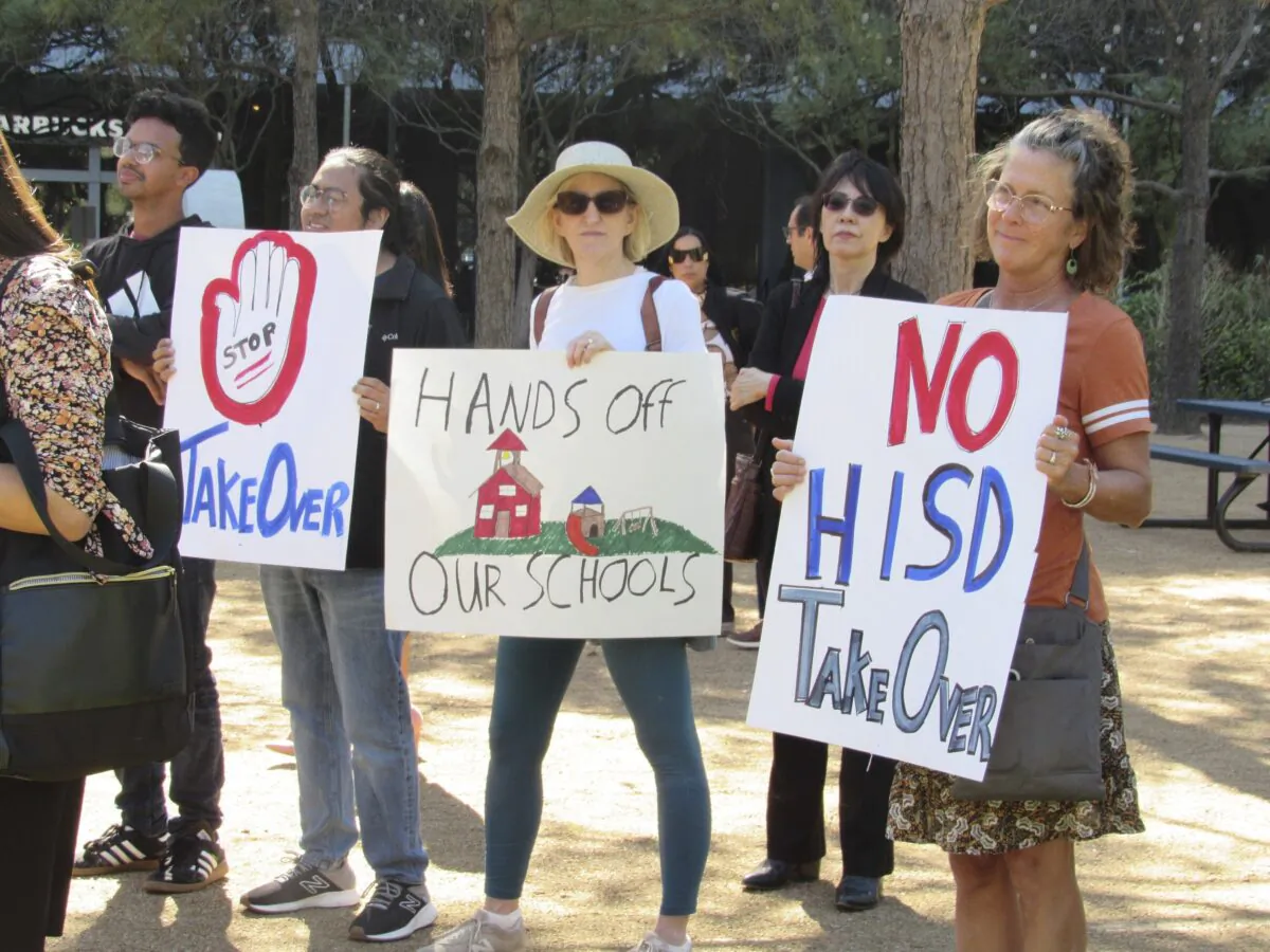 People hold up signs at a news conference in Houston on March 3, 2023, while protesting the proposed takeover of the city's school district by the Texas Education Agency. (Juan A. Lozano/AP Photo)