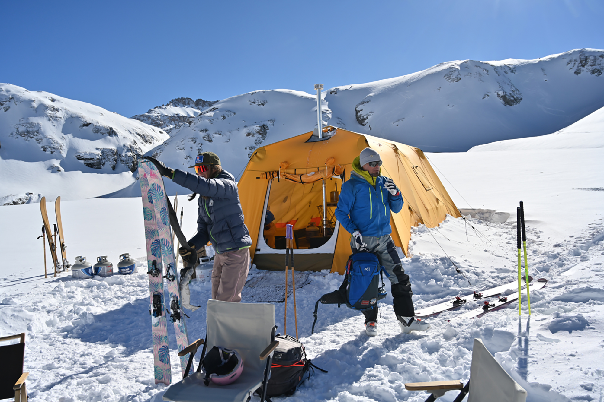 people outside their tent in the mountains