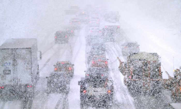 Plows, at right, try to pass nearly stopped traffic, due to weather conditions, on Route 93 South, in Londonderry, N.H., on March 14, 2023. (Charles Krupa/AP Photo)