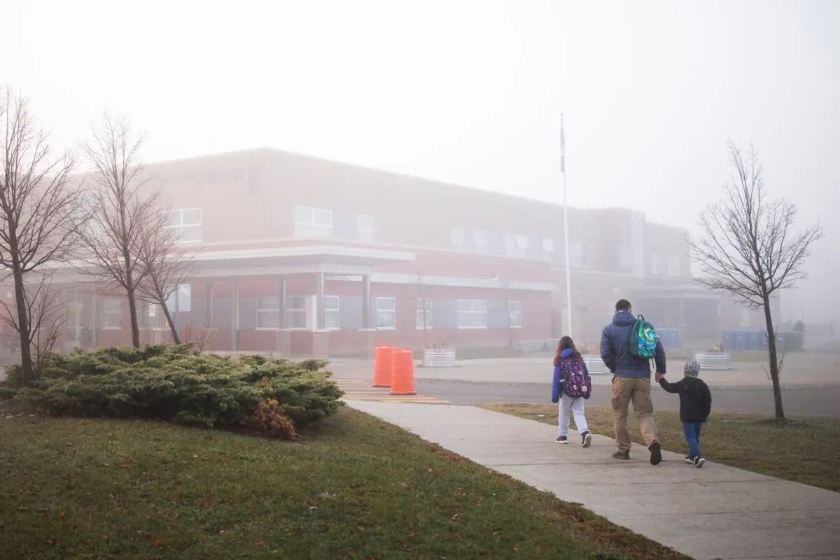 A parent walks his children to school in Milton, Ont., on Nov. 4, 2022. (The Canadian Press/Nick Iwanyshyn)