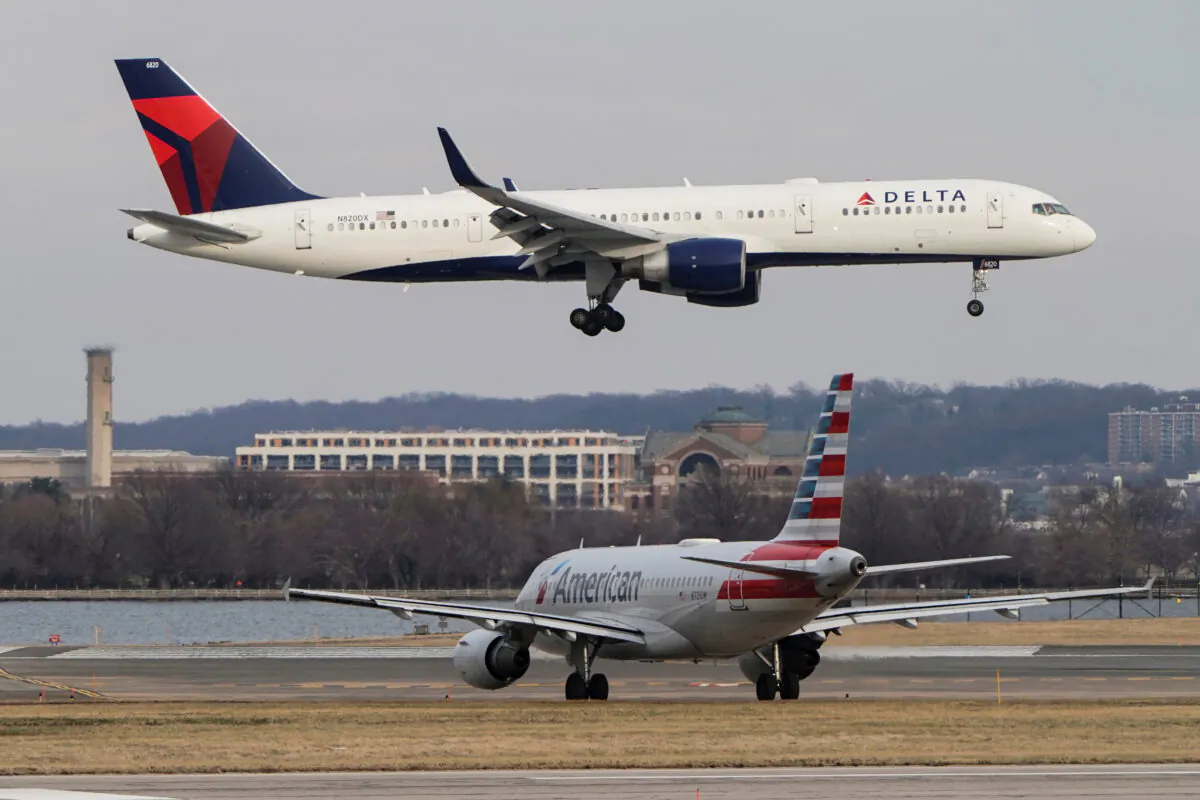 An American Airlines aircraft taxis as a Delta Air Lines aircraft lands at Reagan National Airport in Arlington, Va., on Jan. 24, 2022. (Joshua Roberts/Reuters)