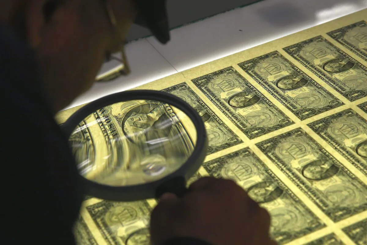 Printing Supervisor Donavan Elliott inspects sheets of one dollar bills run through the printing press at the Bureau of Engraving and Printing in Washington, D.C., on March 24, 2015. (Mark Wilson/Getty Images)