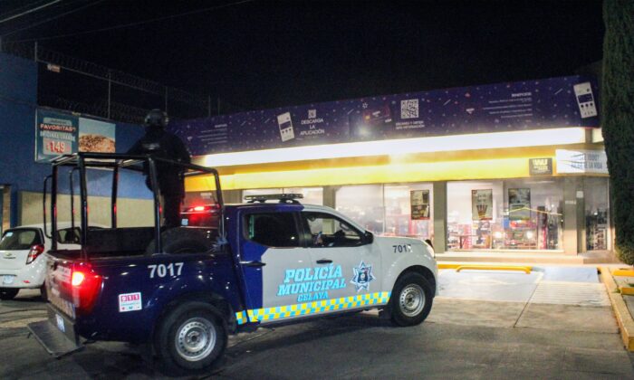 Municipal police stand outside a convenience store that was attacked during various shootings and roadblocks by armed groups operating in the area, in Celaya, Guanajuato state, Mexico, on Jan. 31, 2023. (Jesus Valencia/AFP via Getty Images)