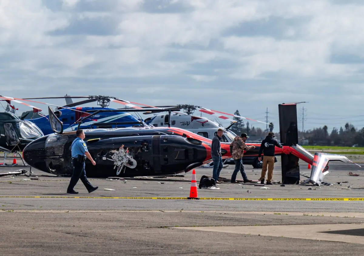Officials inspect a crashed helicopter at Sacramento Executive Airport in Sacramento, Calif., on March 15, 2023. (Nathaniel Levine/The Sacramento Bee via AP)