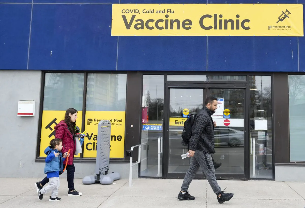 People walk past a vaccine clinic during the COVID-19 pandemic in Mississauga, Ont., on April 13, 2022. (The Canadian Press/Nathan Denette)