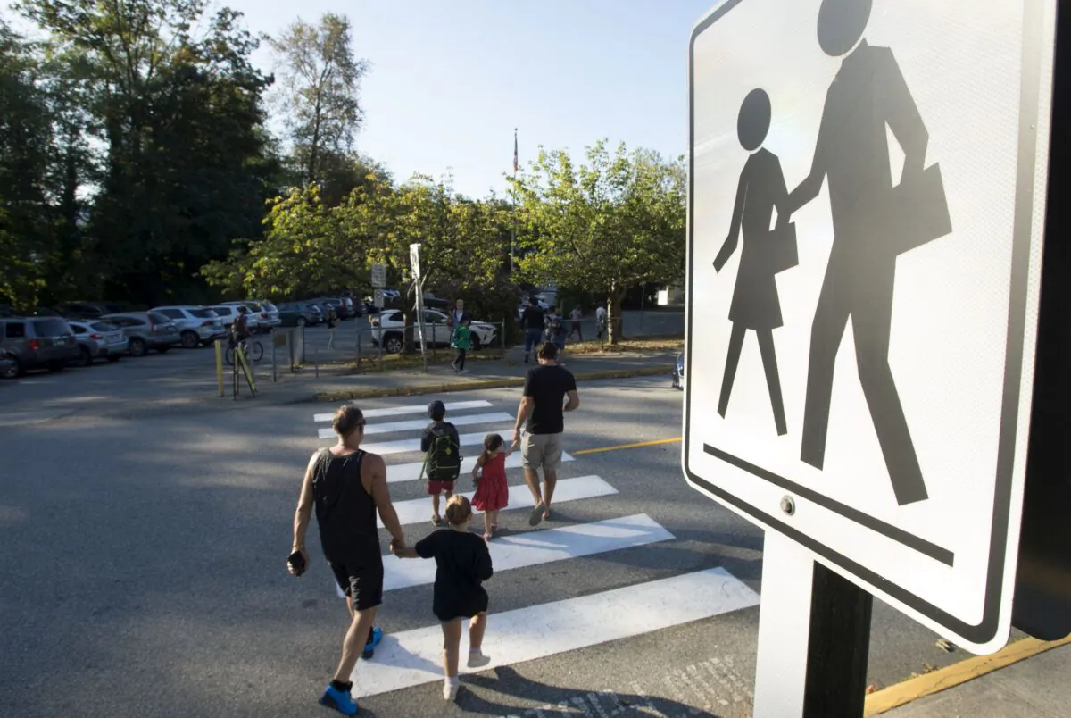 Parents walk their children to school in North Vancouver in a file photo. (The Canadian Press/Jonathan Hayward)