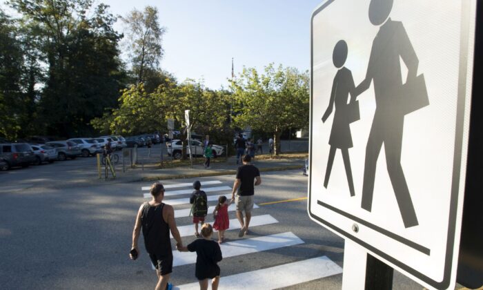 Parents walk their children to school in North Vancouver on Sept. 10, 2020. (The Canadian Press/Jonathan Hayward)