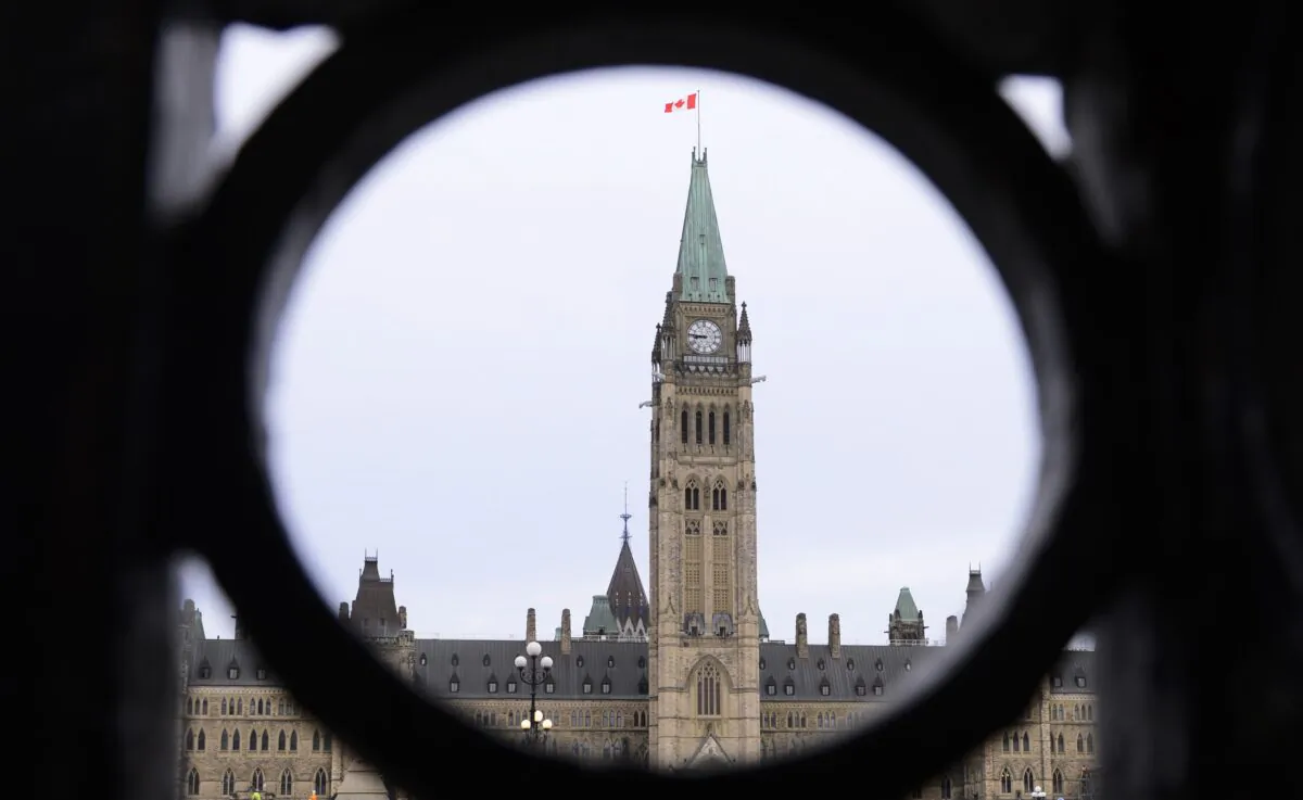 The Parliament Hill Peace Tower is framed in an iron fence on Wellington Street in Ottawa on March 12, 2020. (Sean Kilpatrick/The Canadian Press)