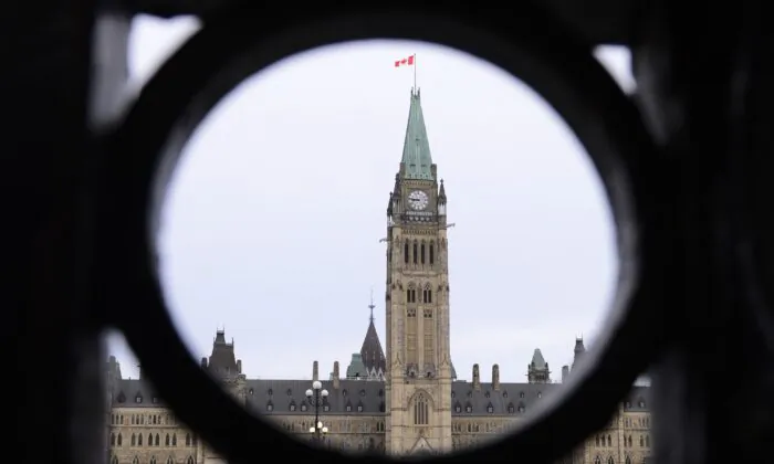The Parliament Hill Peace Tower is framed in an iron fence on Wellington Street in Ottawa on March 12, 2020. (Sean Kilpatrick/The Canadian Press)