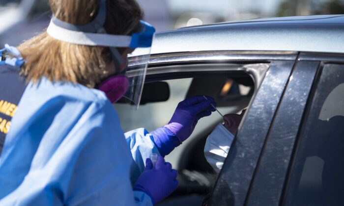A paramedic administers a nasal swab at a drive-through COVID-19 test centre in Ottawa on Sept. 20, 2020. (The Canadian Press/Justin Tang)