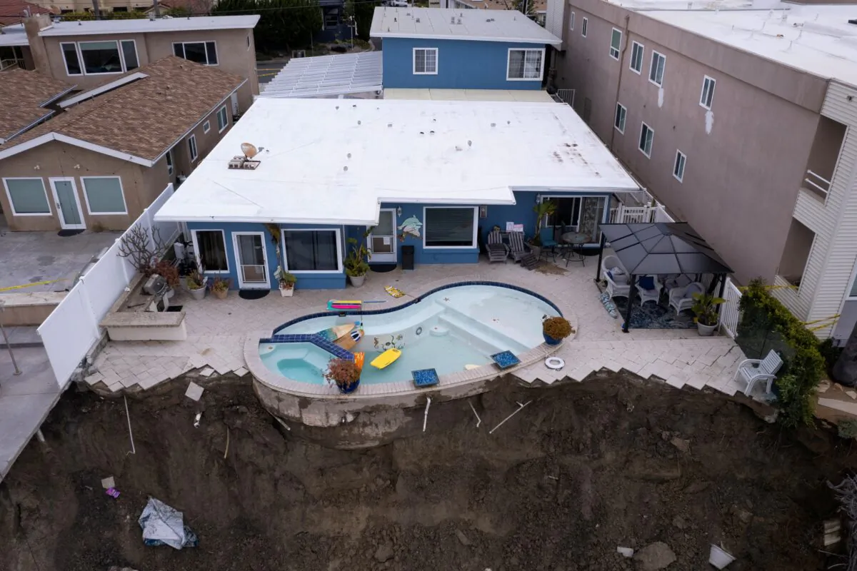 A backyard pool is left hanging on a cliffside after torrential rain brought havoc on the beachfront town of San Clemente, Calif., on March 16, 2023. (Mike Blake/Reuters)