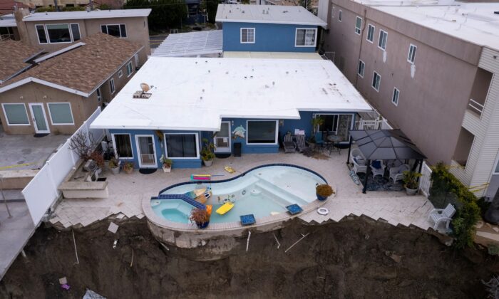 A backyard pool is left hanging on a cliffside after torrential rain brought havoc on the beachfront town of San Clemente, Calif., on March 16, 2023. (Mike Blake/Reuters)