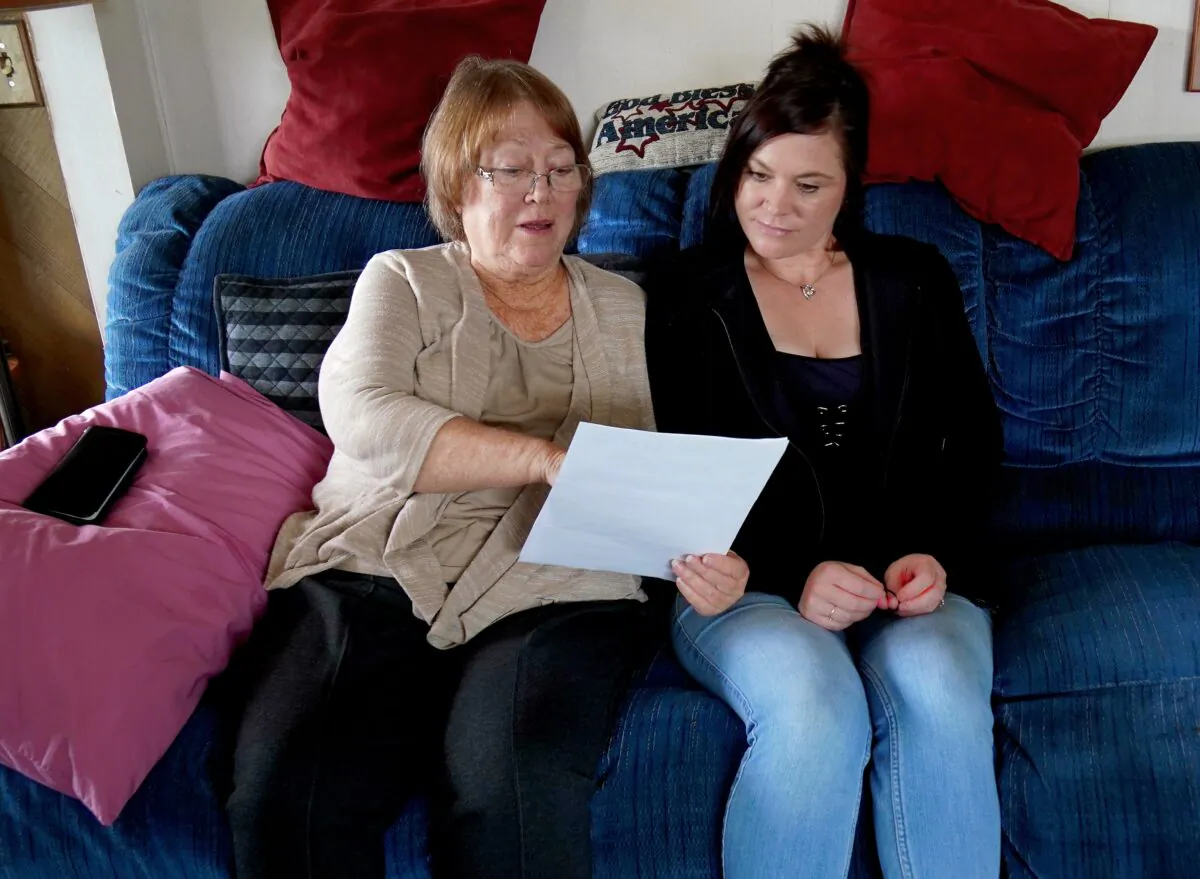 Linda Garinger (L), who has end-stage kidney disease, and her daughter Emily Lewis read the letter from a hospital denying Garinger a kidney transplant operation because she won't get a COVID-19 vaccine. (Allan Stein/The Epoch Times)