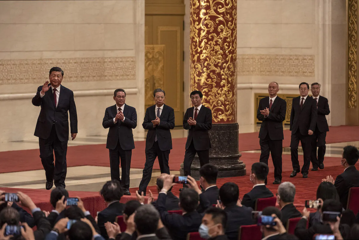 Chinese Communist Party leader Xi Jinping (left) walks with members of the new Standing Committee of the Party’s Political Bureau, (from 2nd left) Li Qiang, Zhao Leji, Wang Huning, Can Qi, Ding Xuexiang, and Li Xi as they arrive for a group photo with journalists at The Great Hall of the People in Beijing, China, on October 23, 2022. (Kevin Frayer/Getty Images)