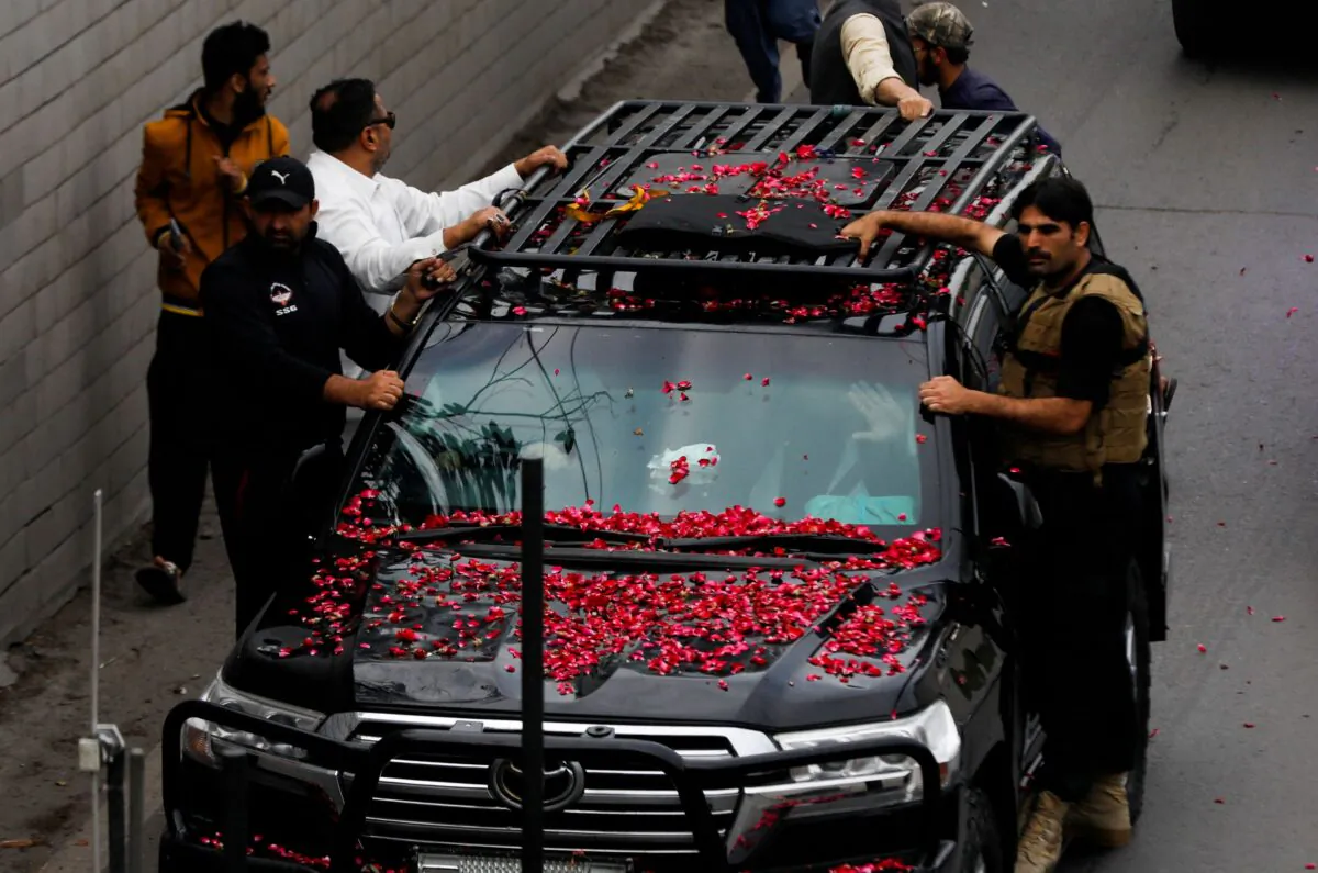 Former Pakistani Prime Minister Imran Khan, waves from the vehicle as he leaves from Lahore to appear before Islamabad High Court, in Lahore, Pakistan, on March 18, 2023. (Akhtar Soomro/Reuters)