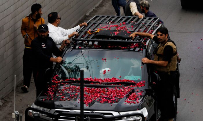 Former Pakistani Prime Minister Imran Khan, waves from the vehicle as he leaves from Lahore to appear before Islamabad High Court, in Lahore, Pakistan, on March 18, 2023. (Akhtar Soomro/Reuters)