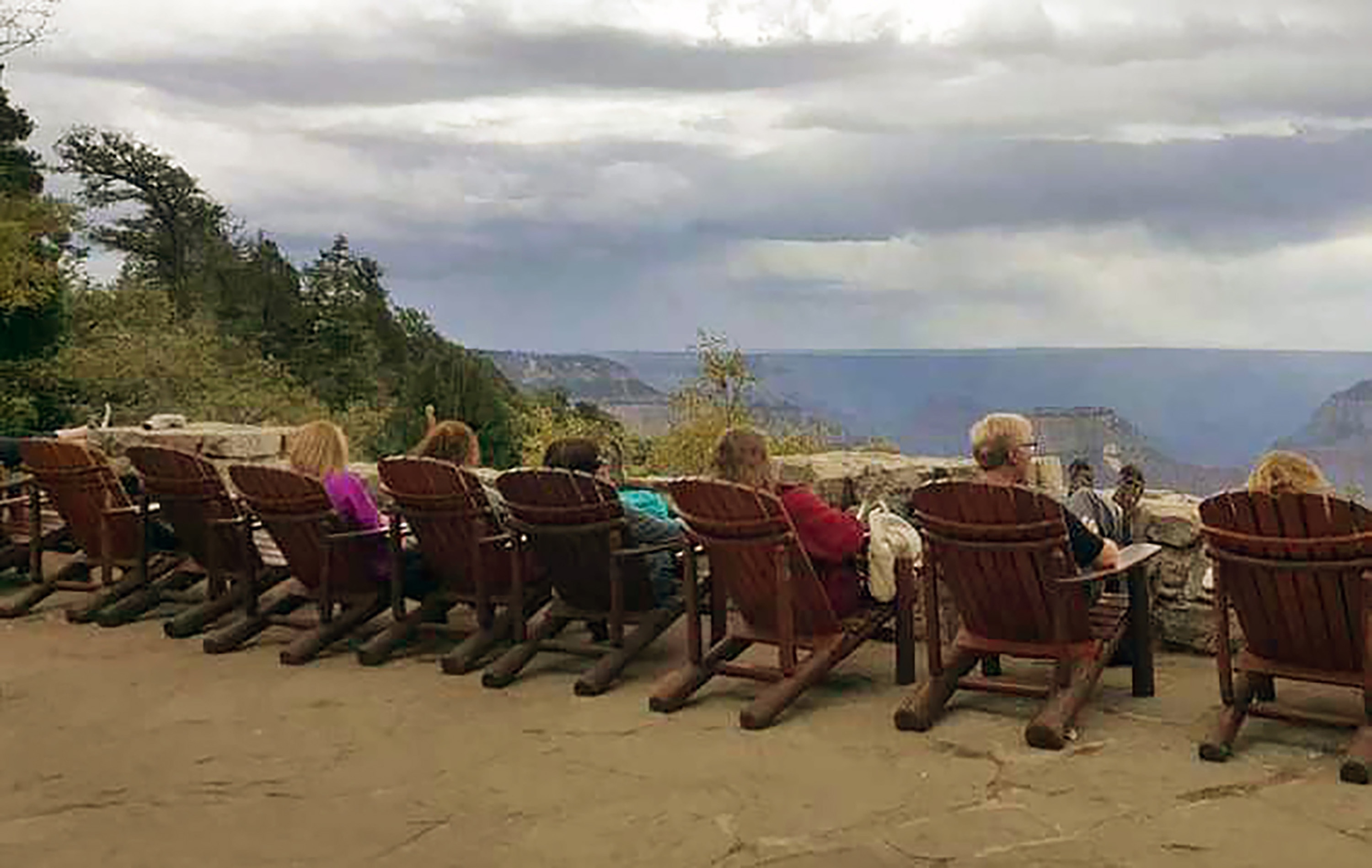 people relaxing in lounge chairs with a view at the Grand Canyon