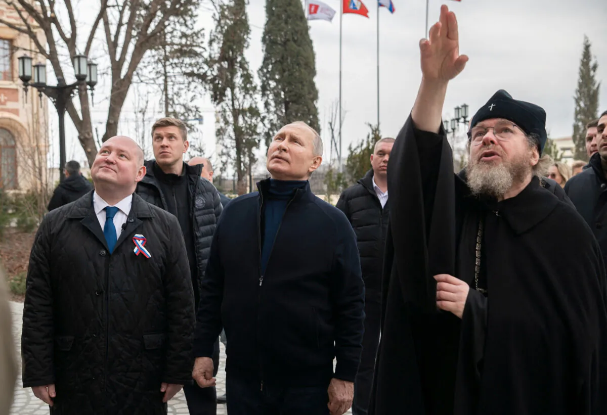 Russian President Vladimir Putin, Governor of Sevastopol Mikhail Razvozhayev and Metropolitan Tikhon (Shevkunov), chairman of the Patriarchal Council for Culture, visit the state museum-preserve "Tauric Chersonese" in Sevastopol, Crimea, on March 18, 2023. (Sputnik/Russian Presidential Press Office/Kremlin via Reuters)
