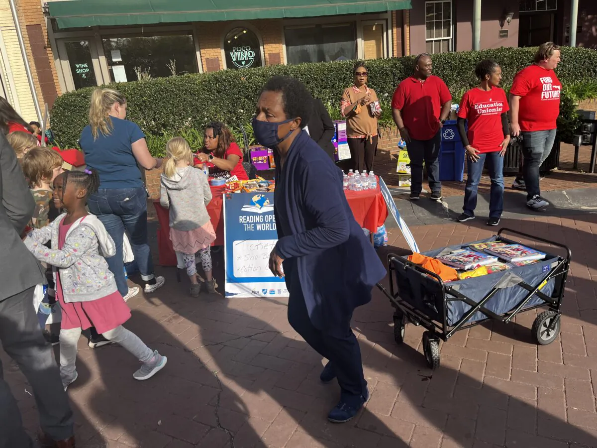 A woman pulls a cart of children's books given out by teachers from three unions protesting against state guidelines requiring them to remove sexually inappropriate books from classrooms during "The Great Florida Read In" near the state Capitol in Tallahassee, Fla., on March 14, 2023.(Nanette Holt/The Epoch Times)