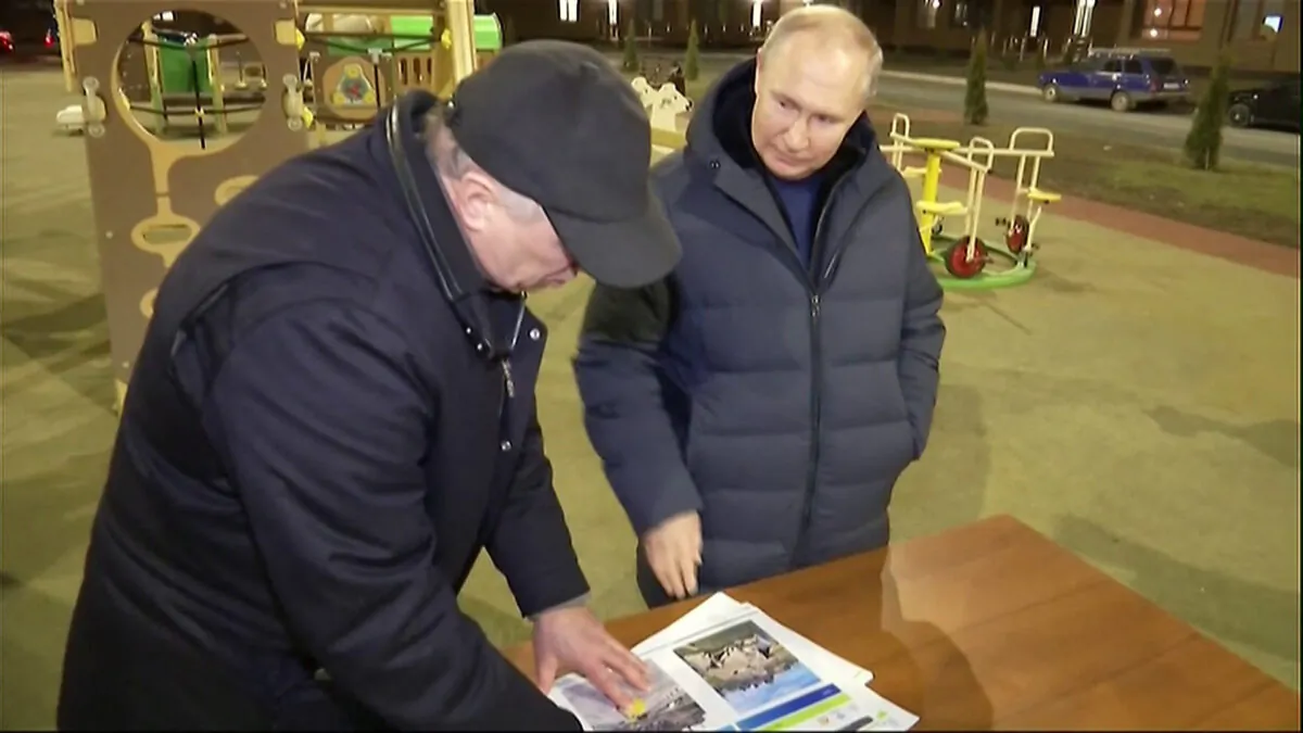 Russia's President Vladimir Putin (R) gestures while speaking with Deputy Prime Minister Marat Khusnullin as they look at reconstruction illustrations while he visits the Russia-annexed city of Mariupol late on March 18, 2023. (Pool/AFP via Getty Images)