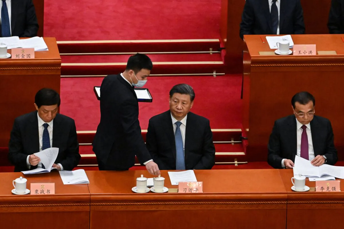 An attendant serves tea to Chinese leader Xi Jinping (C) during the opening ceremony of the Chinese People's Political Consultative Conference (CPPCC) at the Great Hall of the People in Beijing, on March 4, 2023. (Noel Celis/AFP via Getty Images)