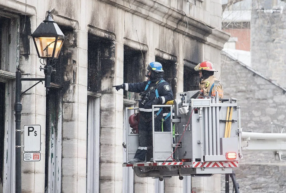 Investigators survey the scene after a fire in Old Montreal on Mar. 19, 2023, that gutted a heritage building. (The Canadian Press/Graham Hughes)