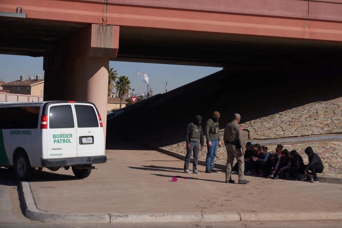 Would-be illegal immigrants wait to be processed by U.S. Border Patrol after crossing into the United States from Mexico via a hole cut in the border fence in El Paso, Texas, on Dec. 21, 2022. El Paso’s border crossings together form one of 11 land ports along Texas’ 1,254 mile-long border with Mexico. (Allison Dinner/AFP/Getty Images)
