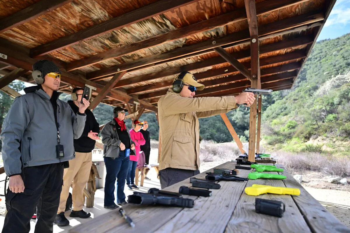 Gun instructor Tom Nguyen (L) watches as Kelly Siu fires a pistol during a Defensive Pistol Class at Burro Canyon Shooting Park in Azusa, California, on Feb. 12, 2023. (Frederic J. Brown/AFP via Getty Images)
