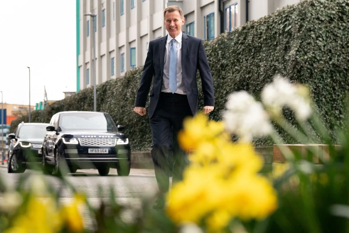 Britain's Chancellor of the Exchequer Jeremy Hunt walks through spring flowers as he arrives to meet  children and staff at Busy Bees Battersea Nursery in south London, on March 15, 2023, after delivering his Budget earlier in the day. (Stefan Rousseau/POOL/AFP via Getty Images)