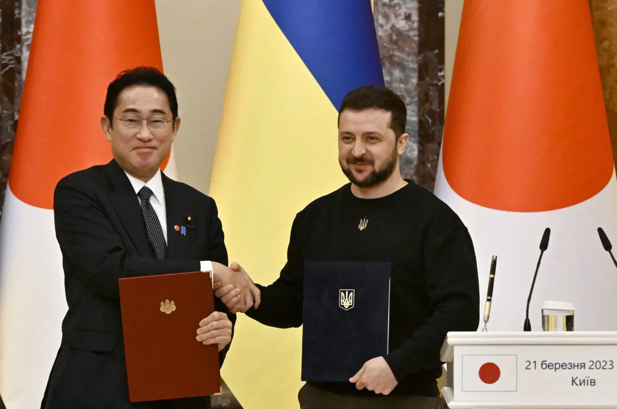 Ukrainian President Volodymyr Zelenskyy (R) and Japan's Prime Minister Fumio Kishida (L) shake hands after the signing of bilateral documents before their joint press conference after their meeting in Kyiv, Ukraine, on March 21, 2023. (Genya Savilov/AFP via Getty Images)