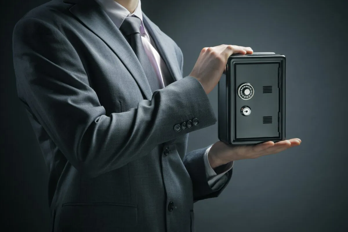 Businessman protecting his savings in the safe. (Shutterstock)