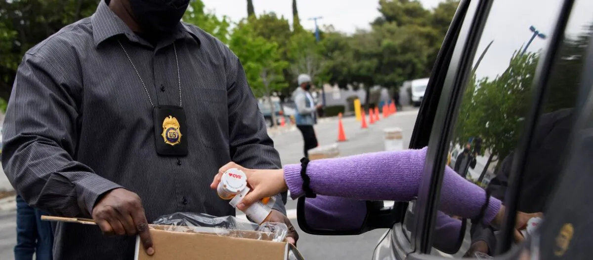 A driver is seen handing drugs over to a Drug Enforcement Administration (DEA) official in a file photo. (Patrick Fallon/AFP via Getty Images)