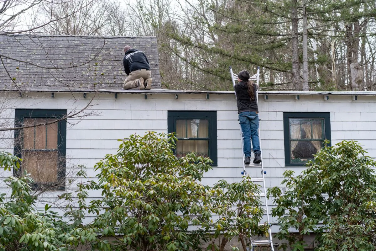 Two workers test for hazardous materials on the site of the future veteran village on Main Street in Port Jervis, N.Y., on March 17, 2023. (Cara Ding/The Epoch Times)