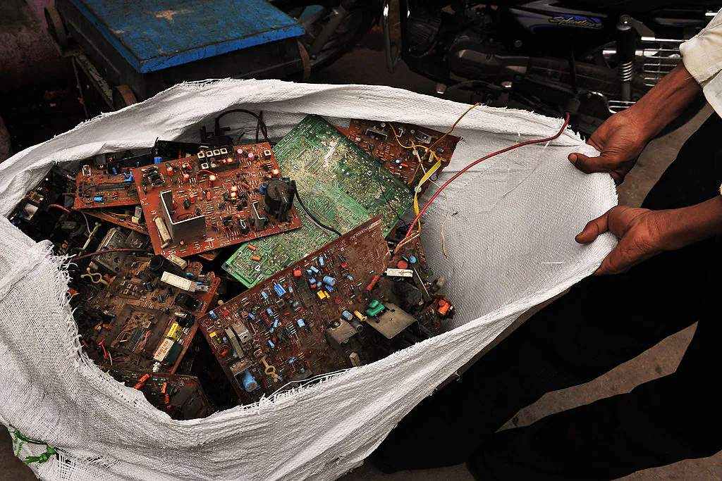 An Indian labourer pulls a sackful of circuit boards after dismantling a computer at a scrap computer workshop in Bangalore on Oct. 30, 2009. (Dibyangshu Sarkar/AFP via Getty Images)