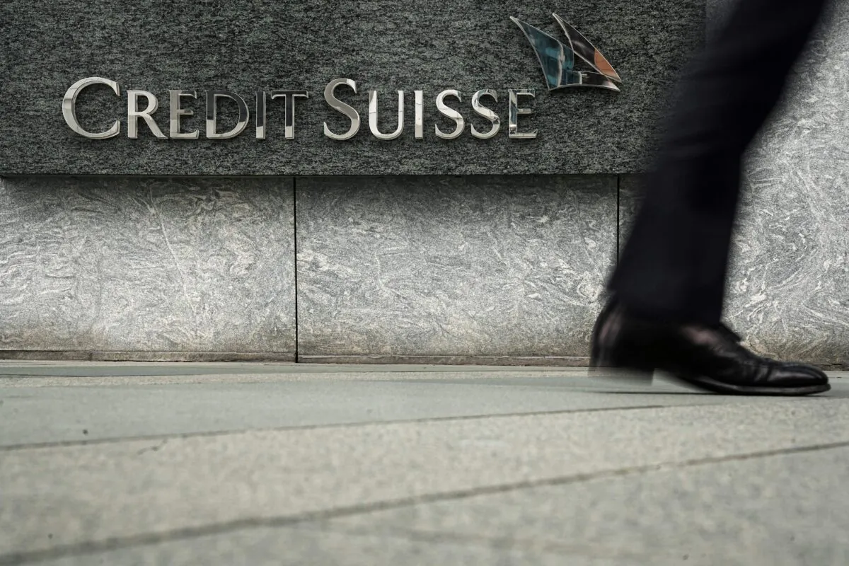A pedestrian walks past a logo of Credit Suisse outside its office building in Hong Kong, on March 21, 2023. (Lam Yik/Reuters)