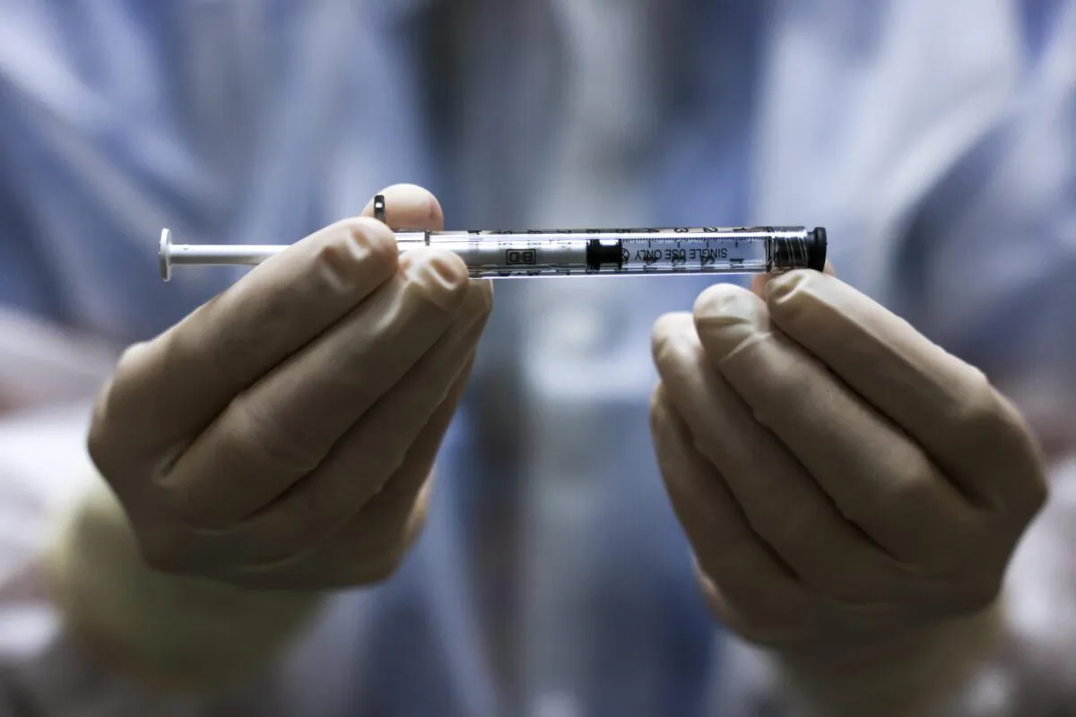 A person holds a dose of the Johnson & Johnson COVID-19 vaccine before it is administered in a clinical trial in Aurora, Colo., on Dec. 15, 2020. (Michael Ciaglo/Getty Images)