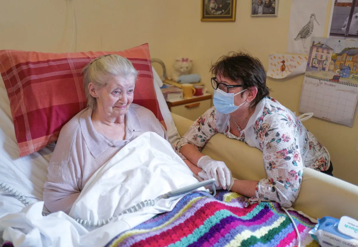 Care home resident Dot Hendy holds her daughter Louise's hand for the first time in many weeks after Louise successfully passed a COVID-19 test immediately before meeting her mother at the King Charles Court Care Home, Falmouth, England, on Nov. 18, 2020. (Hugh Hastings/Getty Images)