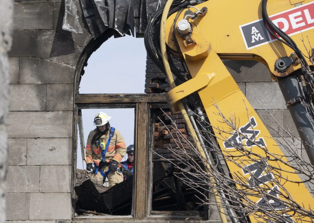 Firefighters enter the building as they continue the search for victims Mar. 21, 2023, at the scene of last week’s fire that left one person dead and six people missing in Montreal. (The Canadian Press/Ryan Remiorz)