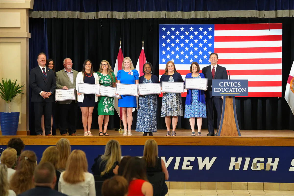 Florida Gov. Ron DeSantis (R) presents $3,000 bonus checks to teachers who had won the Civics Seal of Excellence. (Courtesy of Gov. Ron DeSantis's office)