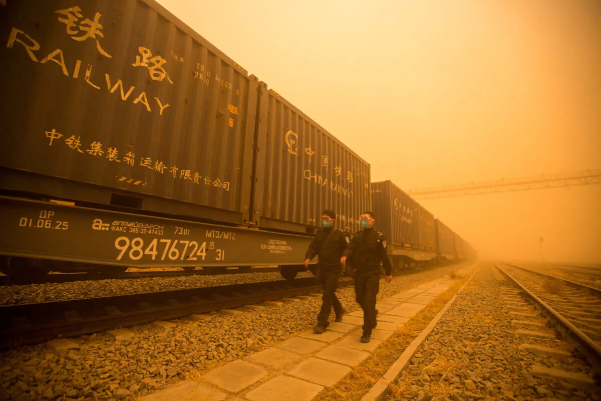 Police officers check cargo trains amid sandstorm at a border checkpoint in Erenhot, Inner Mongolia, China, on March 21, 2023. (cnsphoto via Reuters)
