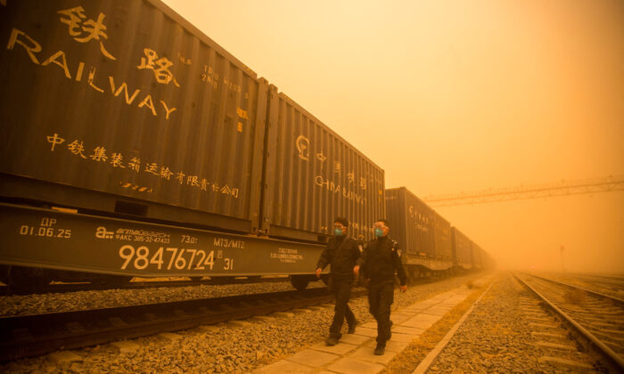 Police officers check cargo trains amid sandstorm at a border checkpoint in Erenhot, Inner Mongolia, China, on March 21, 2023. (cnsphoto via Reuters)