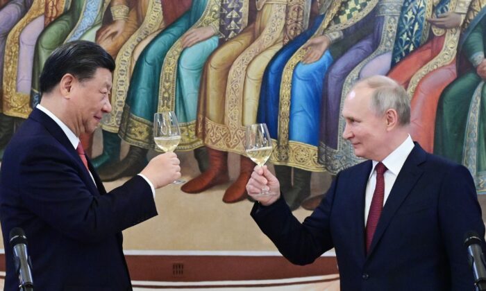 Chiński przywódca Xi Jinping i rosyjski przywódca Władimir Putin wznoszą toast podczas kolacji na Kremlu w Moskwie 21 marca 2023 r. (Pavel Byrkin, Sputnik, Kremlin Pool Photo via AP)