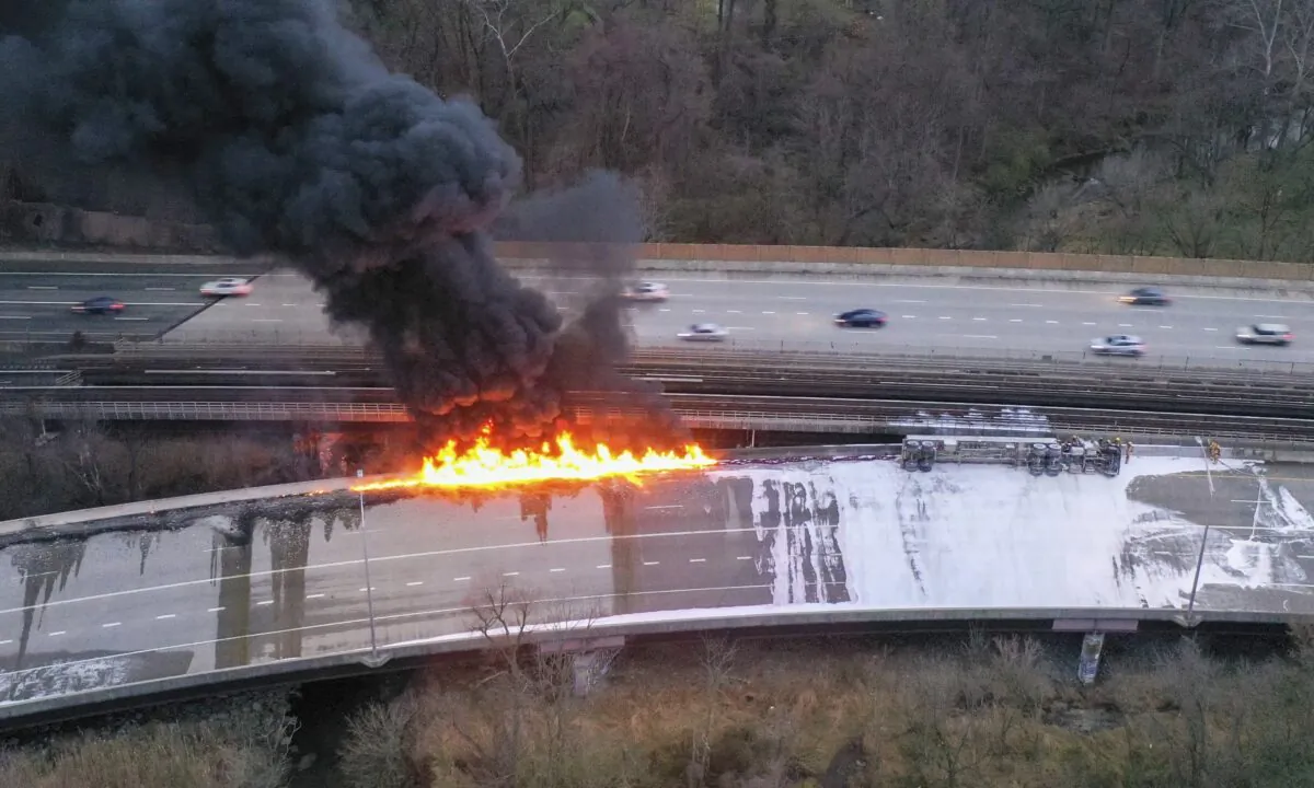 Fuel from an overturned tanker truck burns on northbound Interstate 795 in Pikesville, Md., on March 24, 2023. (Jerry Jackson/The Baltimore Sun via AP)