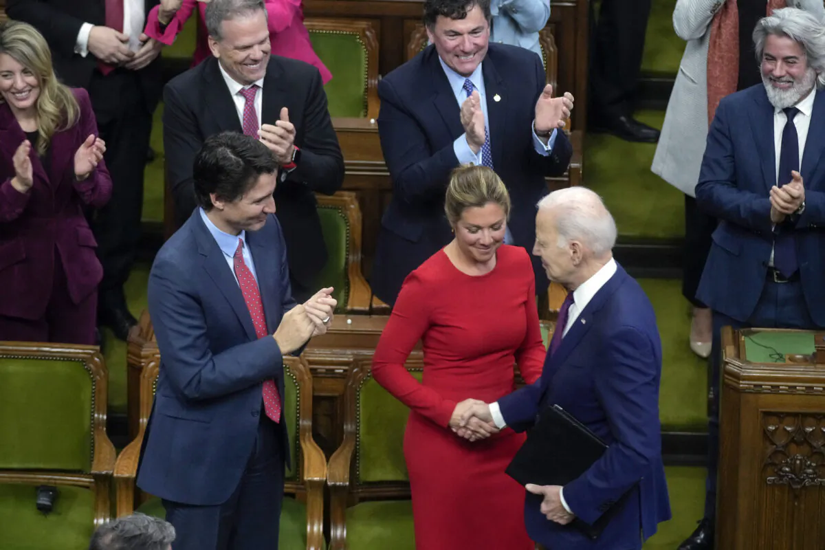 Prime Minister Justin Trudeau applauds as his wife Sophie Gregoire Trudeau shakes hands with U.S. President Joe Biden before Biden addresses the Canadian Parliament, in Ottawa on March 24, 2023. (Andrew Harnik/AFP via Getty Images)
