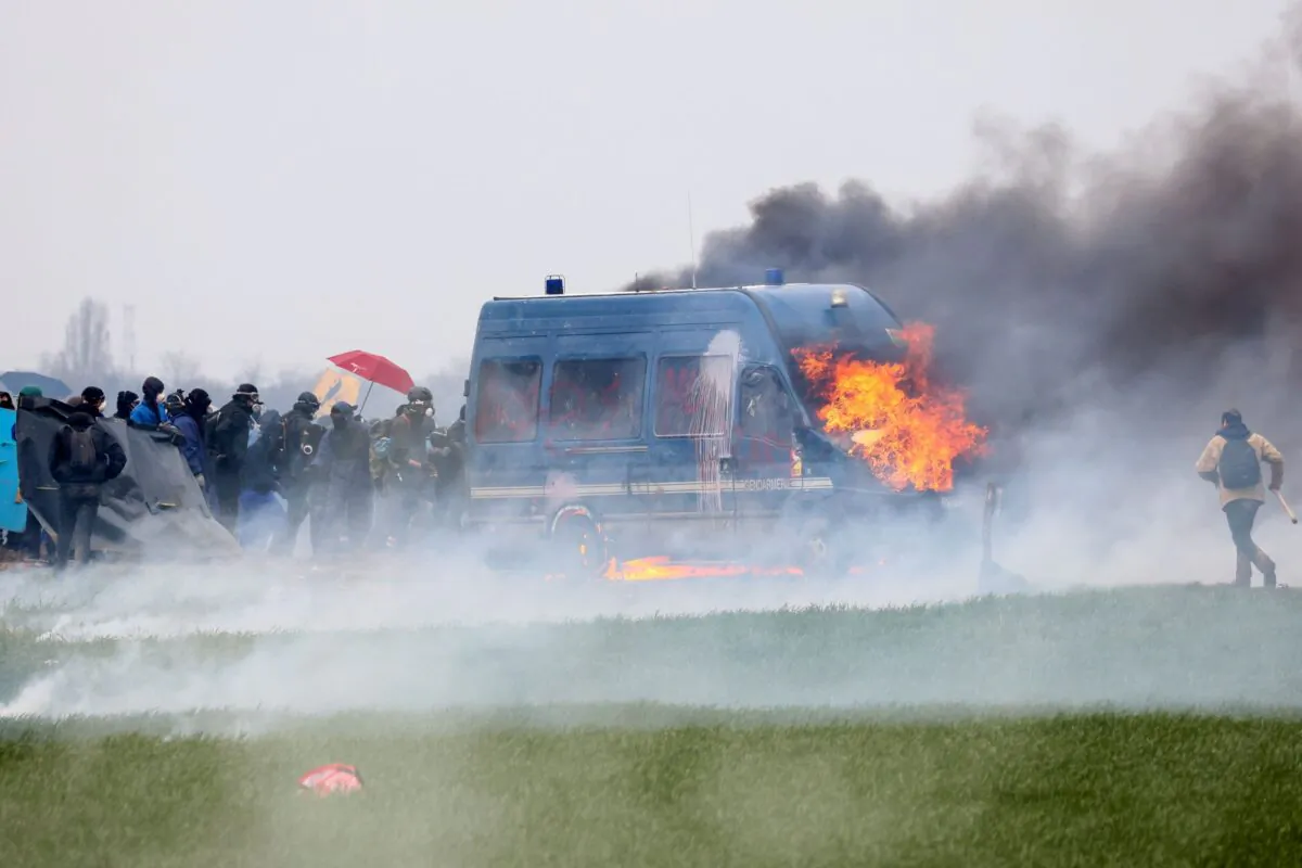A gendarmerie vehicle burns during a demonstration called by the collective "Bassines Non Merci" against the "basins" on the construction site of new water storage infrastructure for agricultural irrigation in western France, in Sainte-Soline, France, on March 25, 2023. (Yves Herman/Reuters)