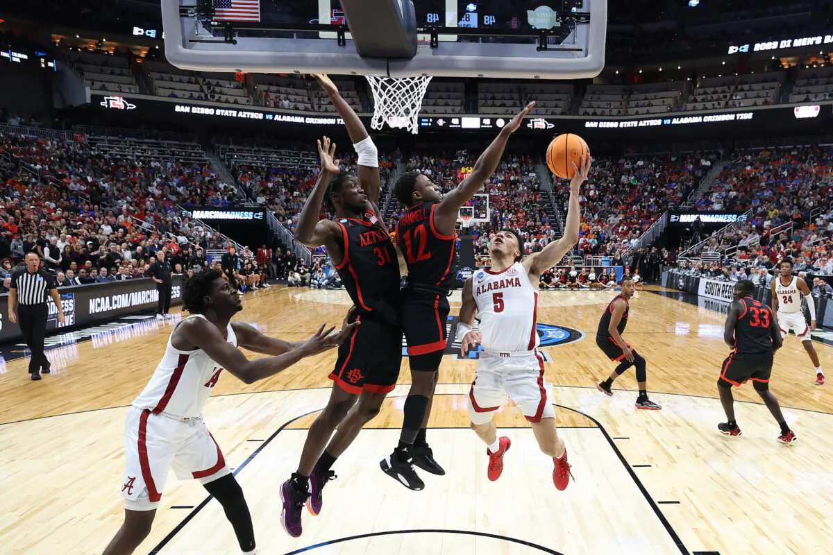 Jahvon Quinerly (5) of the Alabama Crimson Tide shoots against Darrion Trammell (12) of the San Diego State Aztecs and Nathan Mensah (31) of the San Diego State Aztecs during the second half in the Sweet 16 round of the NCAA Men's Basketball Tournament at KFC YUM! Center in Louisville, Ky., on March 24, 2023. (Andy Lyons/Getty Images)