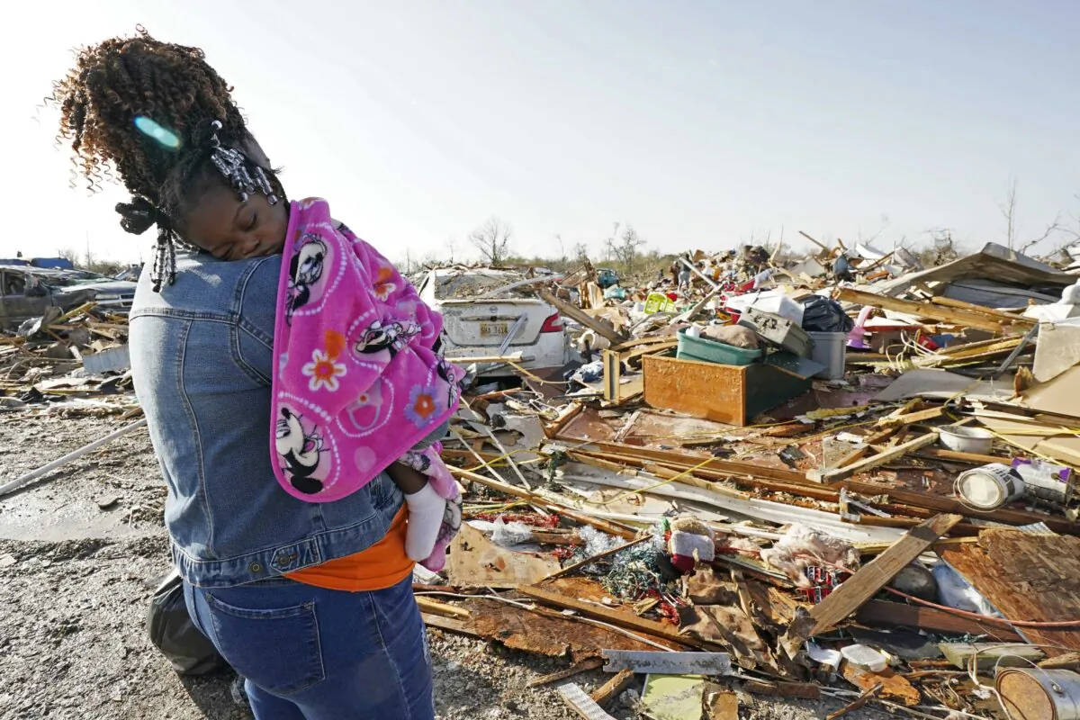 Wonder Bolden cradles her year-old grand daughter Journey Bolden as she surveys the remains of her mother's tornado demolished mobile home in Rolling Fork, Miss., on March 25, 2023. (Rogelio V. Solis/AP Photo)