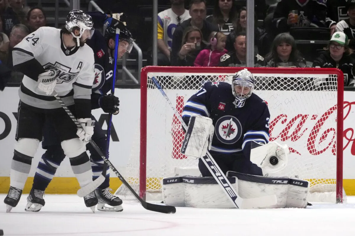 Winnipeg Jets goaltender Connor Hellebuyck, right, stops a shot during the first period of an NHL hockey game against the Los Angeles Kings in Los Angeles on March 25, 2023. (Marcio Jose Sanchez/AP Photo)